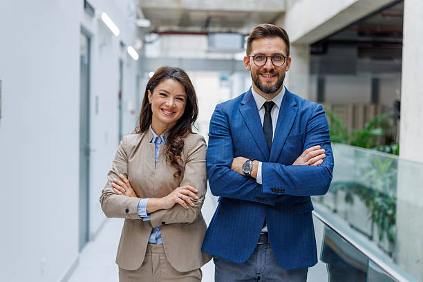 istock Professionals standing together smiling in modern office hallway 2253559436