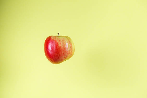 istock A Floating Fresh Apple Positioned on a Bright Yellow Background for a Vibrant Aesthetic 2253560065