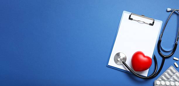 istock Stethoscope with pills and clipboard on color background, top view 2253561771