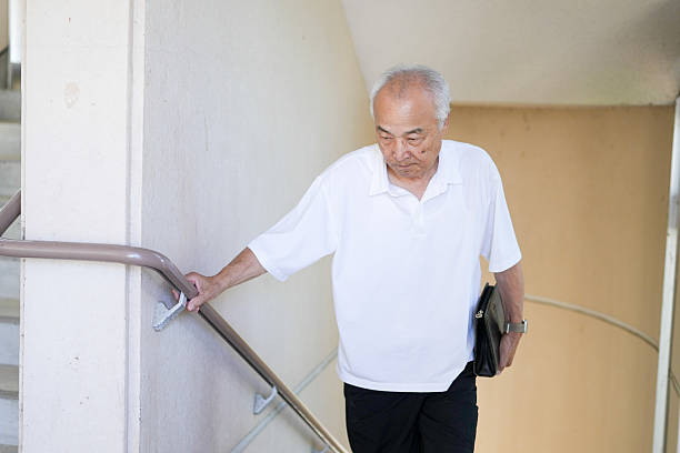 istock An elderly man is walking down a staircase with a briefcase in his hand 2253562841