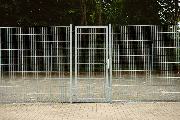A modern steel gate with durable wire mesh enhances accessibility in outdoor spaces, serving as a secure and visually striking addition that contributes to the environments aesthetic appeal