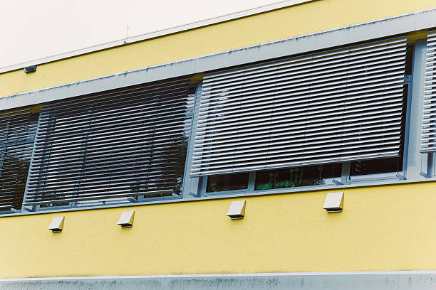 This stunning modern architectural design showcases beautifully crafted window shutters, set against a bright and vibrant yellow exterior that captures the eye and enhances the overall aesthetics