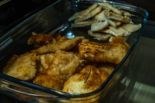 Fried cod, carp, in a glass ovenproof dish, traditional Christmas dishes, sliced fish fried in deep oil, realistic photo
