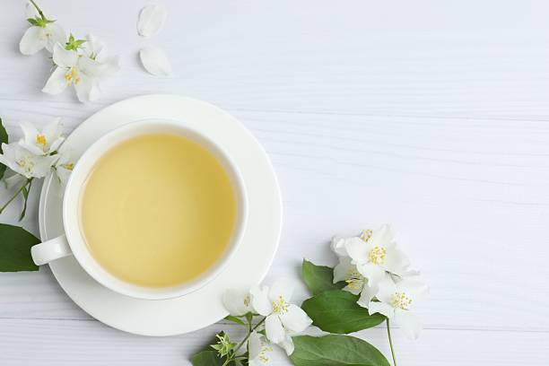 istock Cup of tea with jasmine flowers on white background, close up 2253565742