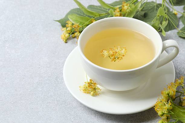 istock Green tea with fragrant linden in transparent cup on white background 2253565993