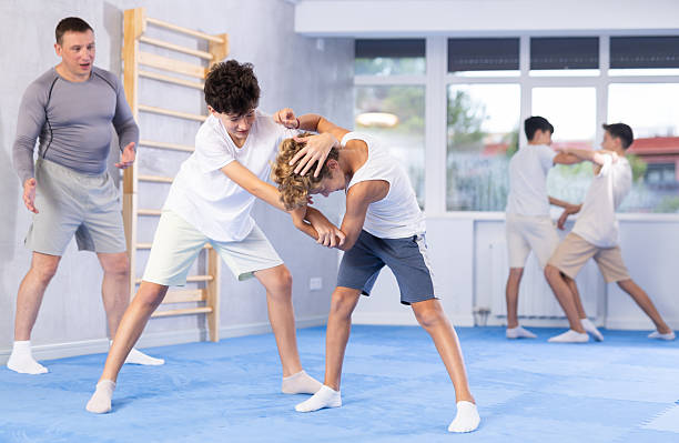 istock Diligent preteen student practicing self-defense techniques in pairs 2253566655