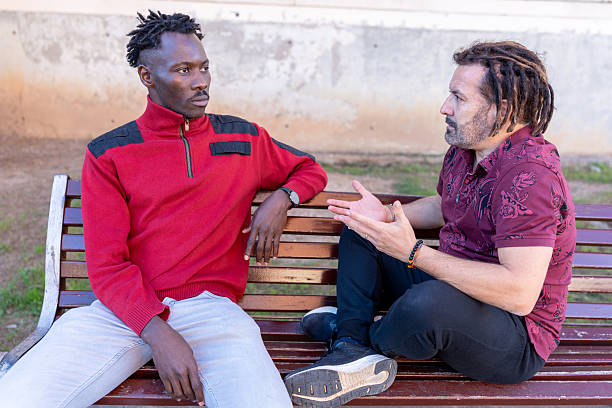 istock Two men having a serious discussion on a park bench outdoors 2253567166