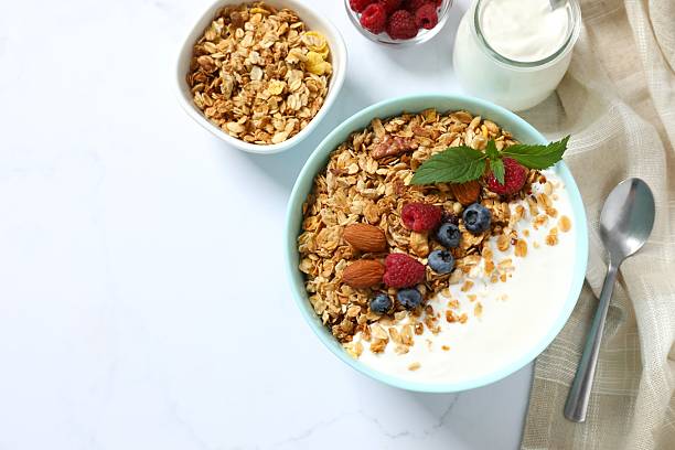 istock Delicious granola with berries and yogurt on a light background 2253569750