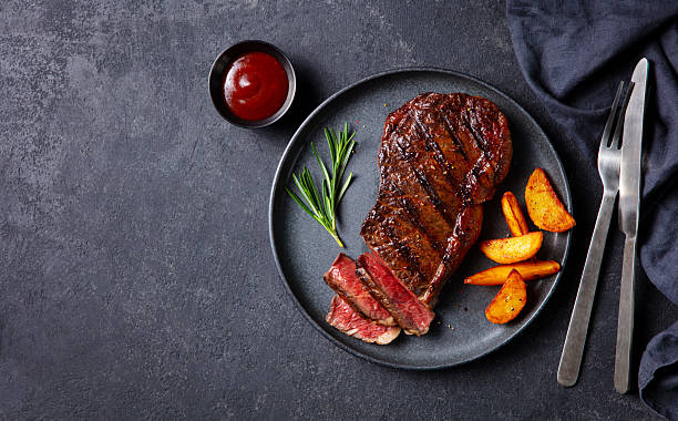 istock Beef Steak medium rare on a black plate. Dark grey background. Copy space. Top view. 2253571611