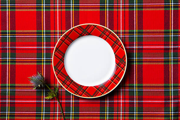 istock Classic tartan dinner plate with thistle accent, traditional Scottish dining setup. Close up. Copy space. Top view. 2253571620