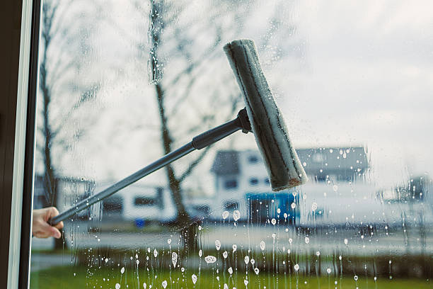 istock A hand is holding a window squeegee to effectively clean the glass surface, allowing for a fresh and clear perspective of the outdoor view beyond, ensuring optimal visibility and shine 2253572864