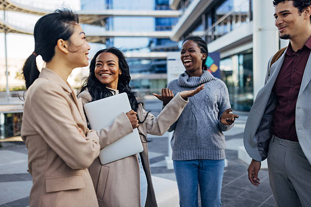 istock A multi-ethnic group of business people casually chatting outdoors, surrounded by modern office buildings, enjoying a relaxed moment in an urban corporate environment 2253574178