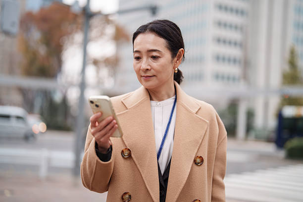 istock Senior businesswoman using smartphone in a modern financial district 2253576781