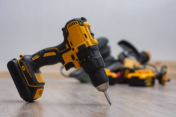 istock Cordless drill surrounded by various power tools on a wooden floor. Construction equipment, DIY tools and workshop hardware for repair, renovation and professional craftsmanship projects. 2253577297