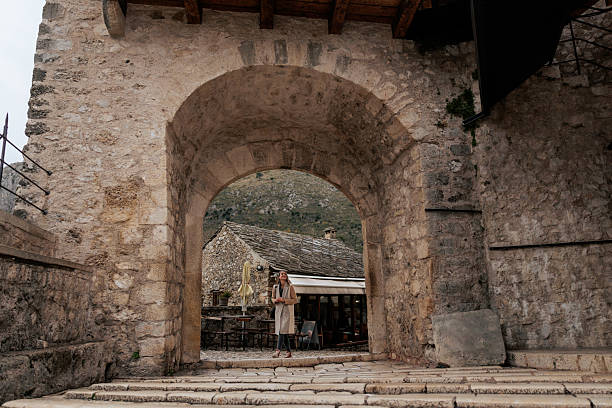 istock Woman Standing Beneath A Stone Archway 2253579703