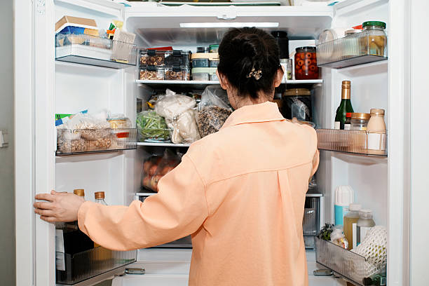 istock Woman Looking Inside Open Refrigerator for Food 2253580584
