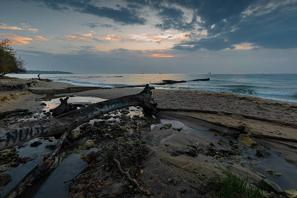 Sunrise on sea and silhouette of log at beach Bang Boet, Prachuap Khiri Khan Province in Thailand.