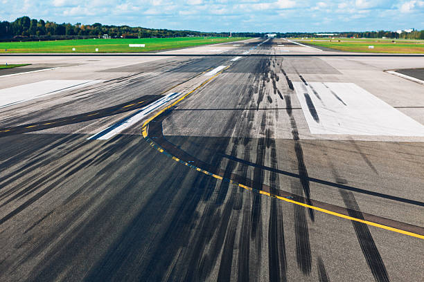 istock Black skid marks streak across a worn runway 2253584048