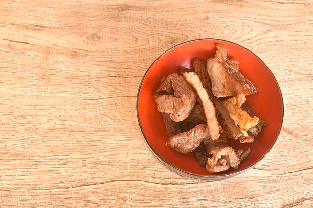 fried crispy salty fermenting beef fat meat with pepper on bowl