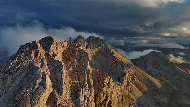 istock Amazing rocky mountains in clouds at sunset 2253585695