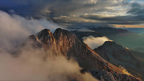 istock Amazing rocky mountains in clouds at sunset 2253585721