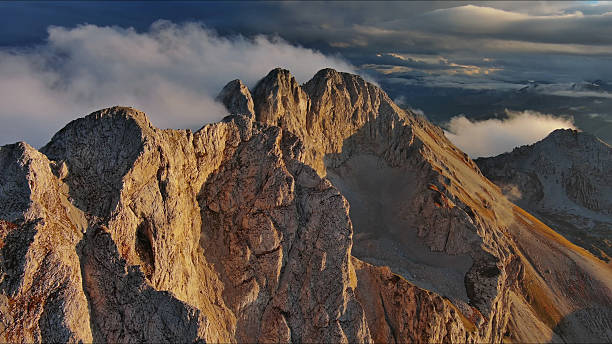 istock Amazing rocky mountains in clouds at sunset 2253585793
