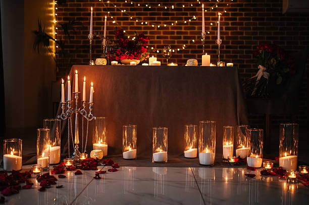 istock Candlelight date in restaurant. Romantic dinner setup at night. Champagne glasses, bouquet flowers. Table setting for couple, Valentine's Day evening, burning candles for surprise marriage proposal. 2253586535