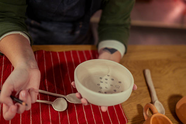 istock Unrecognizable female paints a ceramic bowl in a pottery studio using a paintbrush 2253591024