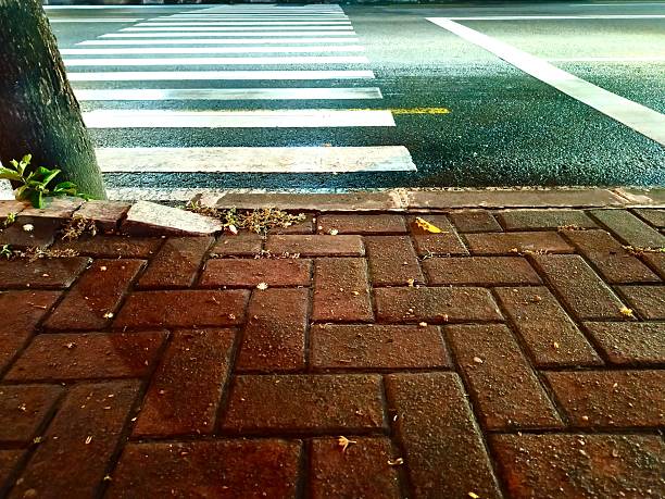 istock Wet urban sidewalk made of clinker bricks at night 2253596975