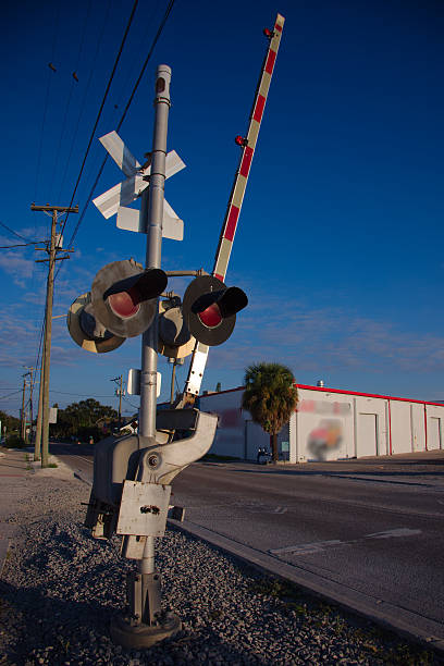 istock Railroad Crossing With Barrier Gate And Tracks Under Clear Blue Sky In Urban Setting 2253600165