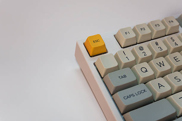 istock White mechanical keyboard with bright yellow Esc key on white background, minimalism, keyboard buttons. A keyboard with a yellow key and red volume button 2253602314