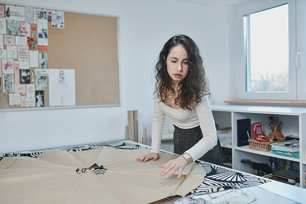 istock Designer Laying Out And Cutting Patterns For Custom Garments 2253603165