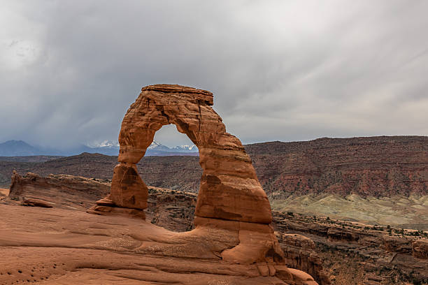 Delicate Arch, a natural sandstone arch formation, rising above a desert landscape in Arches National Park, Utah.