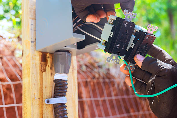 istock Hands connect wires to control panel on wooden post in outdoor setting 2253605612