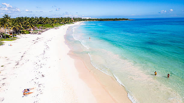 istock Beautiful beach with people swimming in the ocean 2253607036