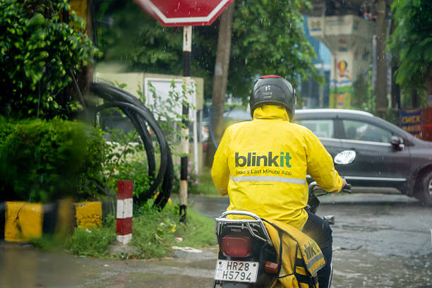 Taipei, Taiwan-05 18 2020: A Motorcyclist wearing a protective mask during the global coronavirus epidemic waits in the rain, on a street of Taipei city, until the light turns green to restart.