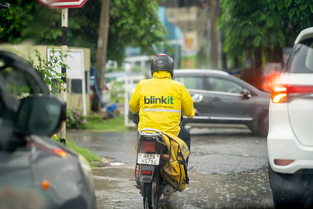 Taipei, Taiwan-05 18 2020: A Motorcyclist wearing a protective mask during the global coronavirus epidemic waits in the rain, on a street of Taipei city, until the light turns green to restart.
