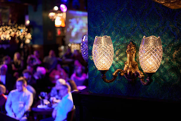 istock Patrons socializing under vintage sconce in cozy lounge 2253610174