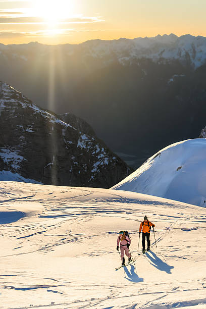 istock Two Skiers on a Snowy Mountain Slope at Sunrise 2253612810