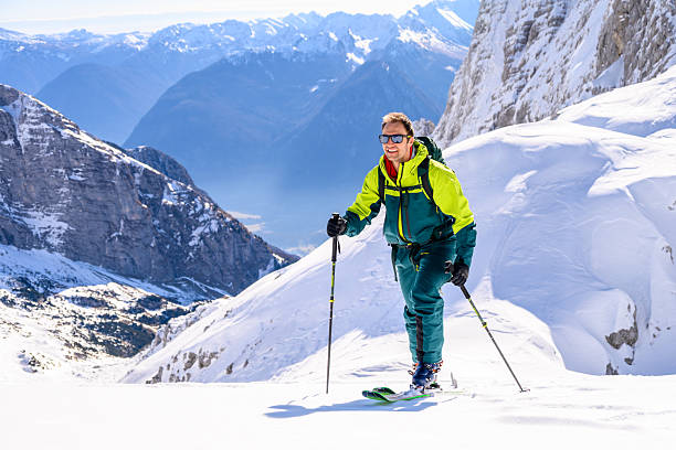 istock Skier on Snowy Mountain Peak with Snow-capped Peaks 2253612812
