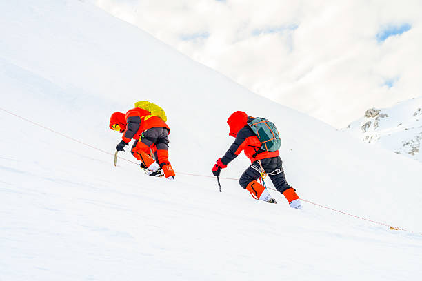 istock Climbers Ascend Snowy Mountain Slope with Ice Axes 2253612819