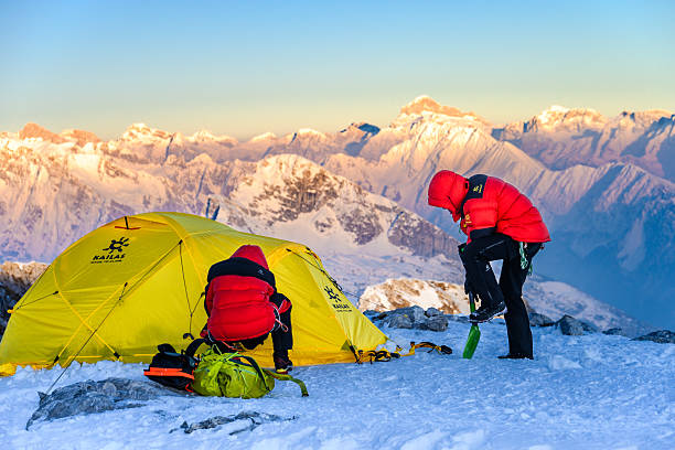 istock Climber in Red Jacket Adjusts Gear on Snowy Mountain Peak 2253612960