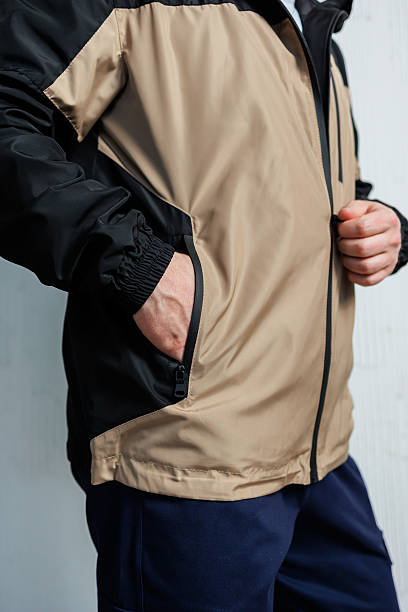 istock A man wears a tan and black jacket with hands in his pockets 2253613376