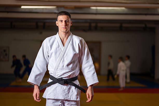 istock Focused Judo Practitioner in White Gi With Black Belt Stands Confident in Training Hall 2253613465