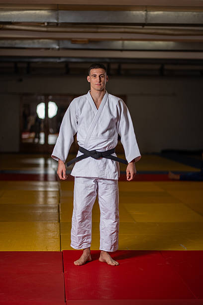 istock Confident Judo Athlete Standing Ready On Mats In Training Dojo With Black Belt 2253613471