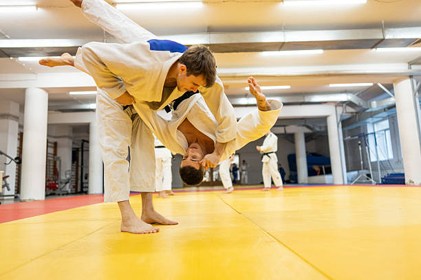 istock Two Judo Practitioners Grapple in a Training Dojo on a Bright Yellow Mat 2253613625