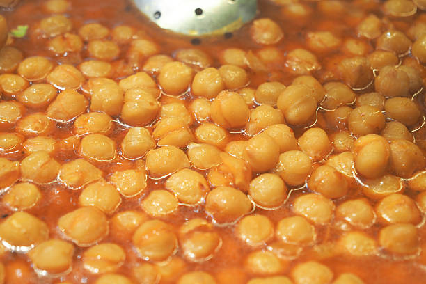 Chickpeas bubble in a rich, spicy sauce on the stove.