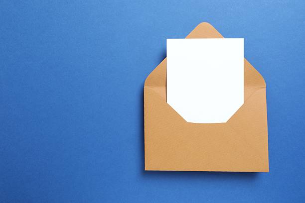 istock Craft envelope with white paper card on blue background 2253615862