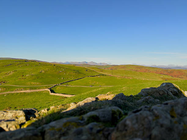 istock Green hills with stone wall and footpath 2253621438