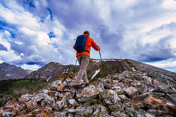 3rd and 4th class scrambling along trek on ridge in alpine terrain. Outdoor adventure and exploration theme hiking alpine ridge to summit peak.